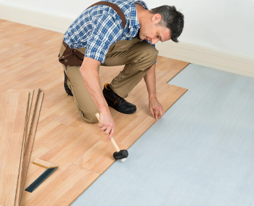 Installer laying new laminate flooring.